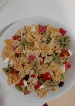 Una foto de Ensalada de pasta con queso feta, salami y tomates