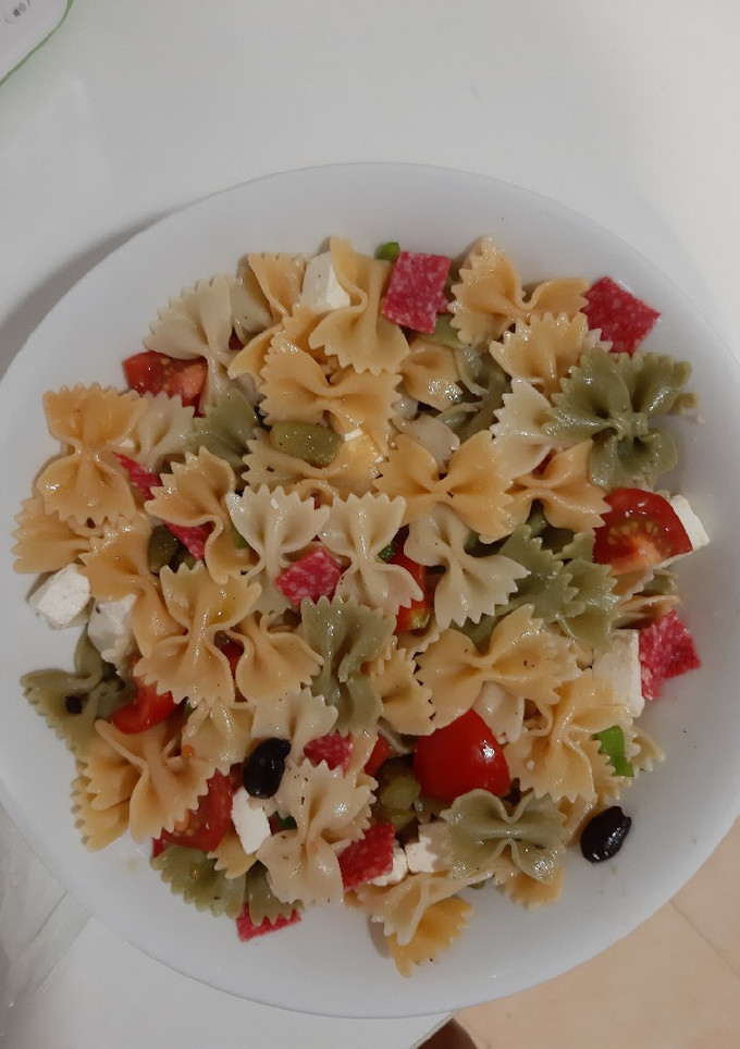 Una foto de Ensalada de pasta con queso feta, salami y tomates