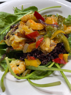 Una foto de Ensalada templada de arroz negro venere con espinacas y gambas