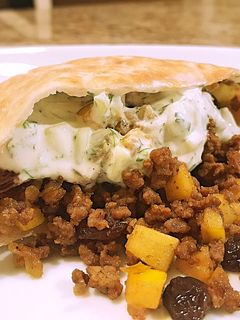 A picture of Curried beef pitas with cucumber sauce.