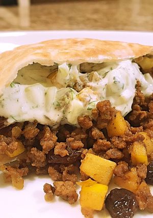 A picture of Curried beef pitas with cucumber sauce.
