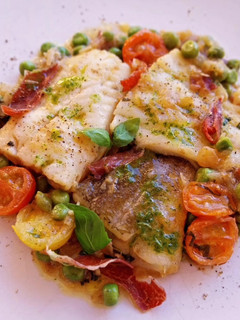 Una foto de Bacalao y merluza con guisantes en salsa con cherrys y albahaca con jamón