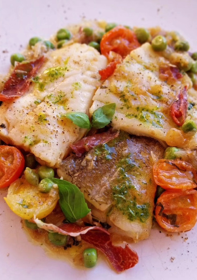 Una foto de Bacalao y merluza con guisantes en salsa con cherrys y albahaca con jamón