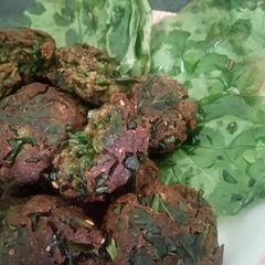 A picture of Spinach kababs with spinach chips.