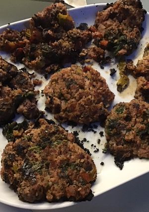 Une photo de Galettes de porc épicées aux fanes de radis, herbes et tomate