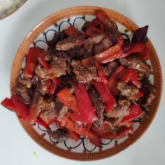 A picture of Stir fried beef with red peppers.