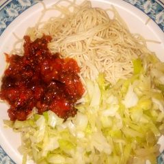 A picture of Pasta with sauce and cabbage.