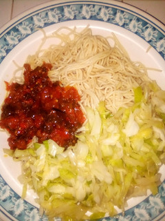 A picture of Pasta with sauce and cabbage.