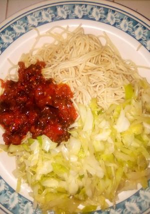 A picture of Pasta with sauce and cabbage.