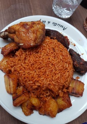 A picture of Jollof rice,fried plantain and chicken.