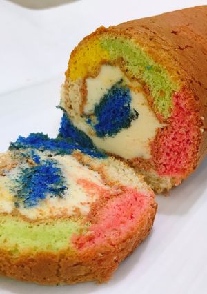 A picture of ROLLED FLUFFY RAINBOW CAKE with LEMON BUTTER FROSTING.