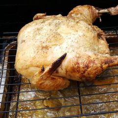 A picture of Whole roasted chicken on the grill.