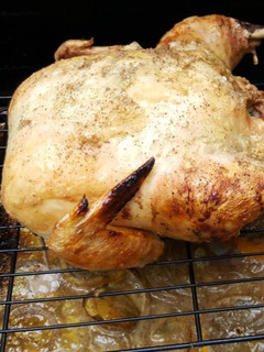 A picture of Whole roasted chicken on the grill.