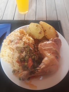 Una foto de Pollo arvejado con arroz y papas doradas