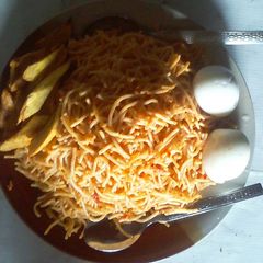 A picture of Spaghetti with fried plantain and boiled egg.