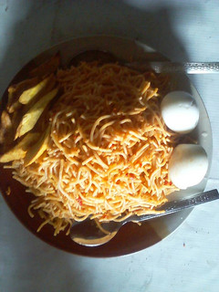 A picture of Spaghetti with fried plantain and boiled egg.