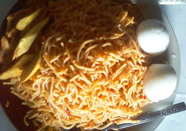 Spaghetti with fried plantain and boiled egg