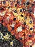 Pizza listada con tres tops: espinacas, quesos, y tomate