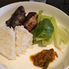 A picture of Mackerel fish, White rice, sambal and green lettuce.