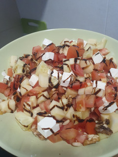 Una foto de Ensalada de tomate, manzana, feta, pepino, nueces y piñones