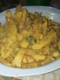 Una foto de Papas fritas con salsa cheddar y verdeo