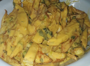 Una foto de Papas fritas con salsa cheddar y verdeo