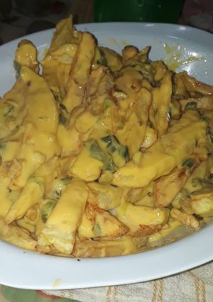 Una foto de Papas fritas con salsa cheddar y verdeo