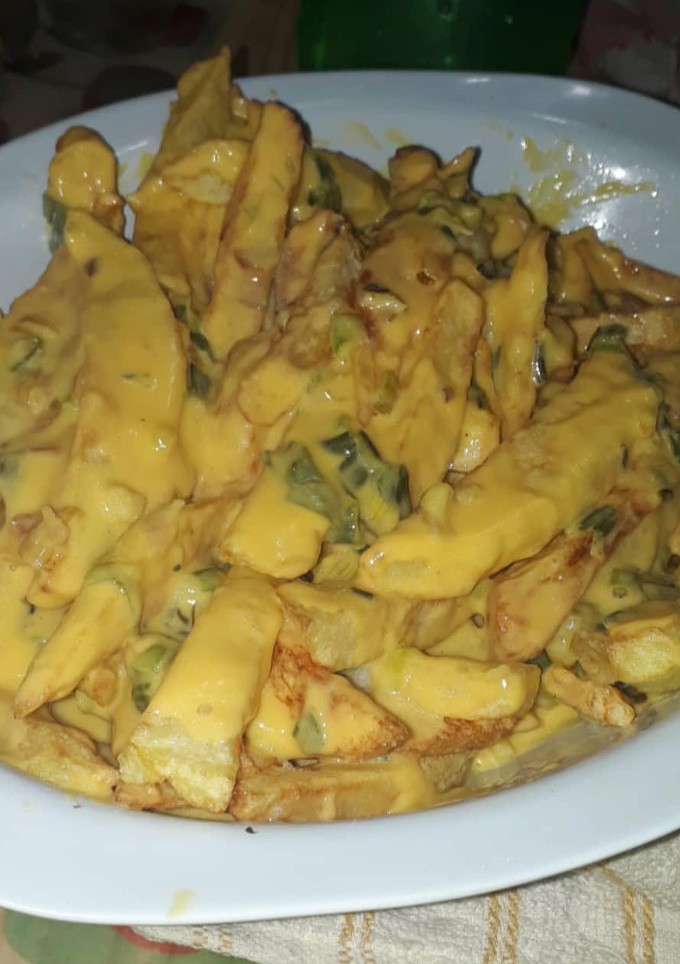 Una foto de Papas fritas con salsa cheddar y verdeo