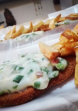 Una foto de Milanesa al verdeo con fritas