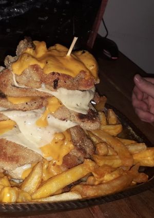 Una foto de Súper torre de milanesa con cheddar y fritas!