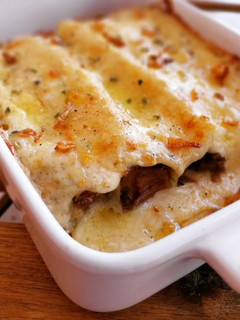 Una foto de Canelones de carrilleras con bechamel de ajo escalivado