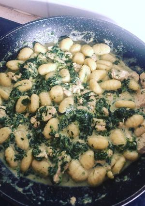 Une photo de Gnocchis aux morceaux de poulet et à la sauce épinards en branches, crème de soja et chèvre frais
