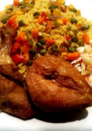 A picture of Jollof rice,fried chicken with coleslaw.