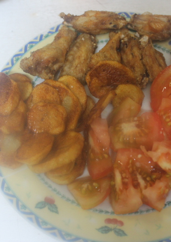 Una foto de Alitas y patatas fritas