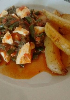 Una foto de Chauchas en salsa de tomate con huevos y papas doradas