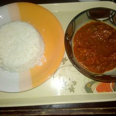 A picture of White rice with tomato stew.