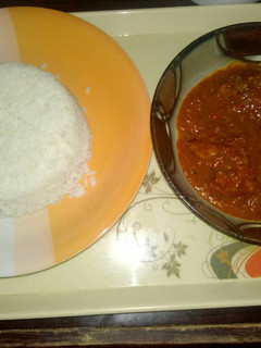 A picture of White rice with tomato stew.