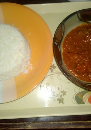 A picture of White rice with tomato stew.