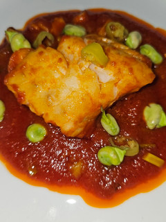 Una foto de Bacalao skrei con salsa de tomate y habitas tiernas