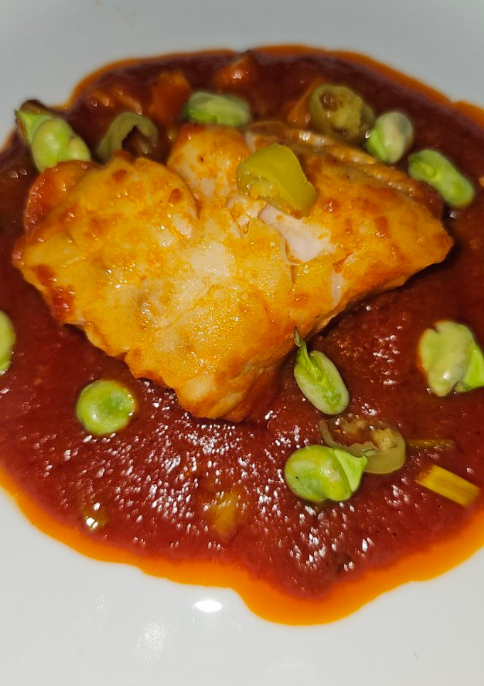 Una foto de Bacalao skrei con salsa de tomate y habitas tiernas