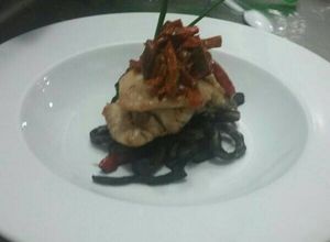 Una foto de Pescado confitado con refrito de calamares en su tinta