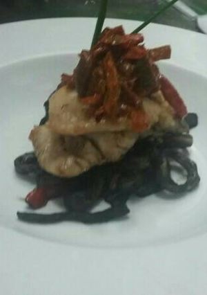 Una foto de Pescado confitado con refrito de calamares en su tinta