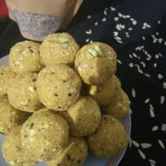 A picture of Besan laddoo with sunflower and flax seeds.