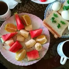 A picture of Bread and eggs with fruits salad.