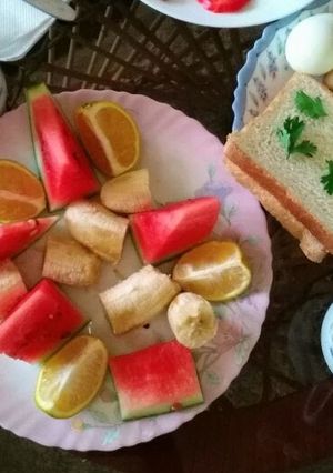 A picture of Bread and eggs with fruits salad.