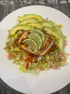 A picture of Chicken breast with green salad.