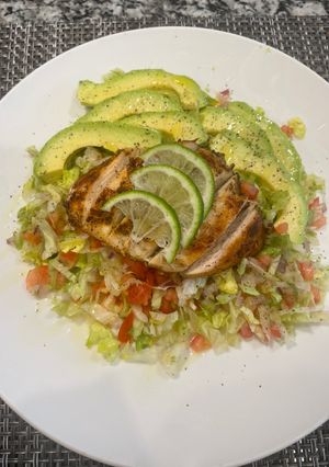 A picture of Chicken breast with green salad.