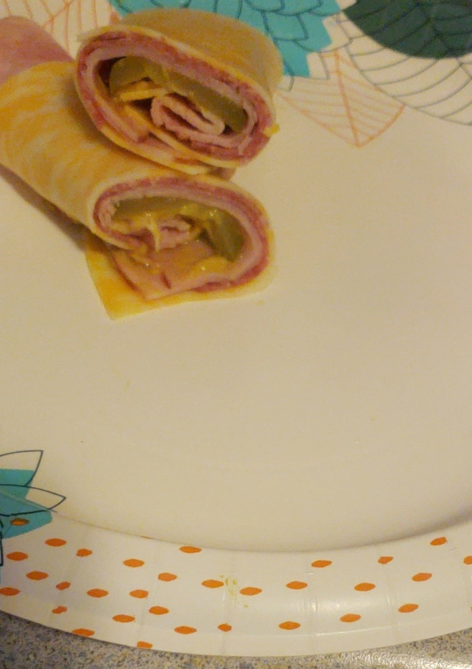 A picture of Ham salami pickle and cheese roll up.