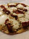 Pizza de pesto, tomate seco y piñones