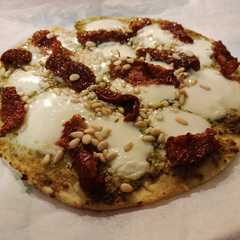 Una foto de Pizza de pesto, tomate seco y piñones